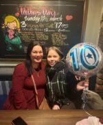 Elaine and Amy in their favourite pub celebrating their 10th kidneyversary. Amy is holding a '10' balloon