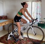 Image of living kidney donor Julie in exercising gear riding a stationary bike in her living room